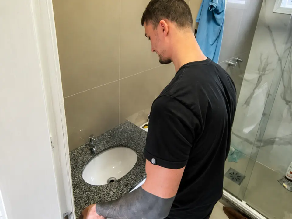 Kauê realizando um pequeno reparo em banheiro